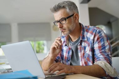 Dizüstü bilgisayarda çalışan iş adamı