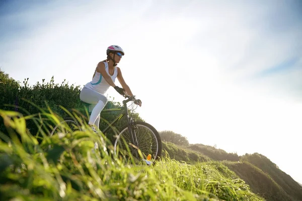 Vrouw in sport outfit paardrijden fiets — Stockfoto