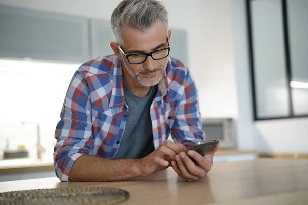 Hombre en casa usando smartphone —  Fotos de Stock