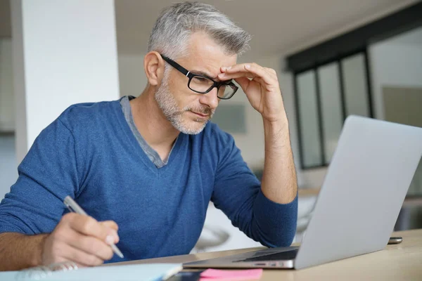 Midaldrende mand, der arbejder - Stock-foto