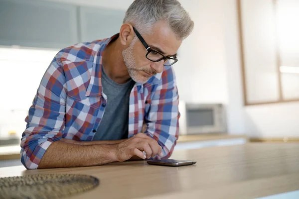 Man thuis met behulp van smartphone — Stockfoto