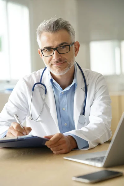 Läkare som arbetar på patientens journal — Stockfoto