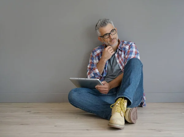 Homem sentado no chão com tablet — Fotografia de Stock