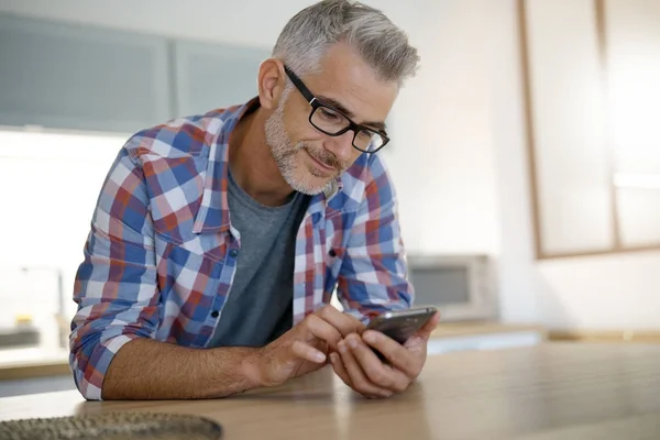 Uomo a casa con smartphone — Foto Stock