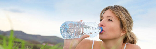 Женщина пьет натуральную воду
  