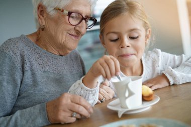 Büyükanne ile çay saati olan kız