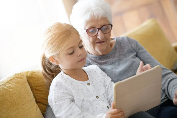 Dziewczyna z babcia za pomocą tabletu — Zdjęcie stockowe