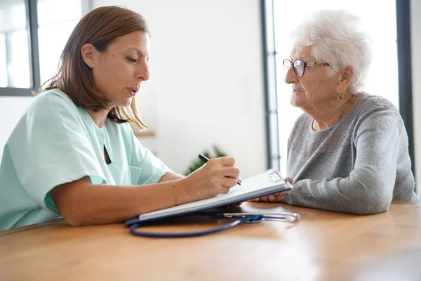 Krankenschwester gibt Frau Rezept — Stockfoto