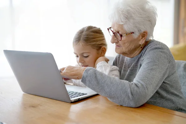 Dizüstü bilgisayar kullanarak büyükanne ile kız — Stok fotoğraf