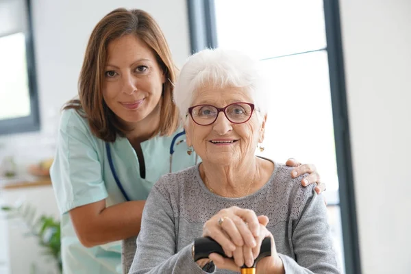 Sjuksköterska besökande gammal kvinna — Stockfoto