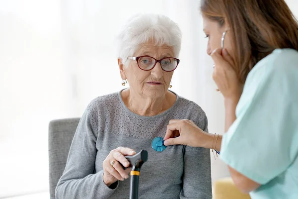 Nurse examining old woman — Stock Photo, Image