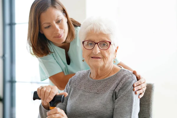 Sjuksköterska besökande gammal kvinna — Stockfoto