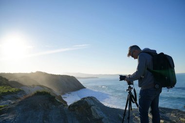 Fotoğrafçı peyzaj fotoğraf çekmek için tripod kullanılması