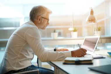 İşadamı dizüstü bilgisayarda çalışma ofisinde arkadan görünüm