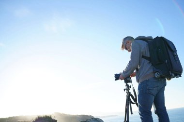 Fotoğrafçı peyzaj fotoğraf çekmek için tripod kullanılması