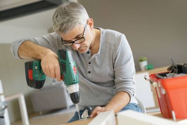 DIY mobilya elektrikli matkap kullanarak montaj adam