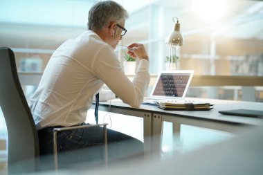 İşadamı dizüstü bilgisayarda çalışma ofisinde arkadan görünüm