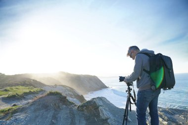 Fotoğrafçı peyzaj fotoğraf çekmek için tripod kullanılması