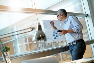 Anaylzing sonuçları listelerinde sırasında telefonda konuşan işadamı