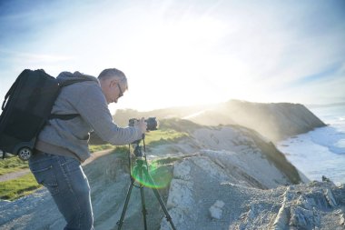 Fotoğrafçı peyzaj fotoğraf çekmek için tripod kullanılması