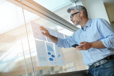 Anaylzing sonuçları listelerinde sırasında telefonda konuşan işadamı