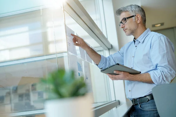 Empresario Analizando Gráficos Resultados Colgados Ventana Oficina — Foto de Stock