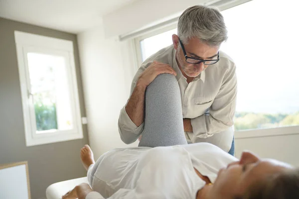 Physiotherapeut Streckt Bein Des Patienten — Stockfoto