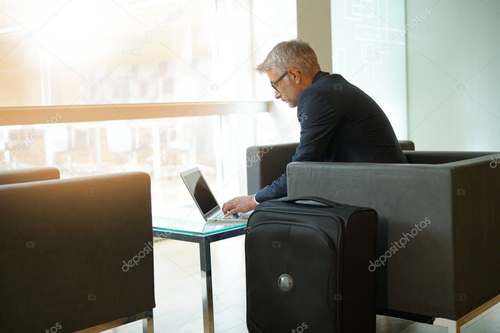 Businessman in waiting room connected with laptop