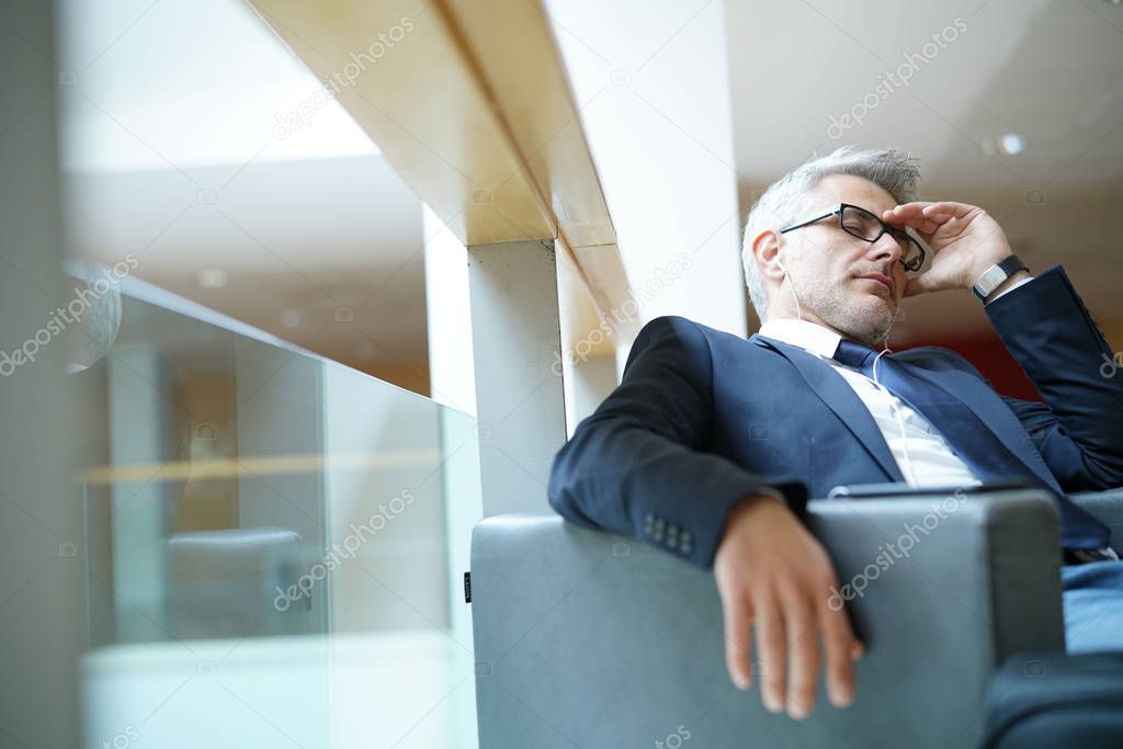 Businessman taking a nap in airport departure lounge