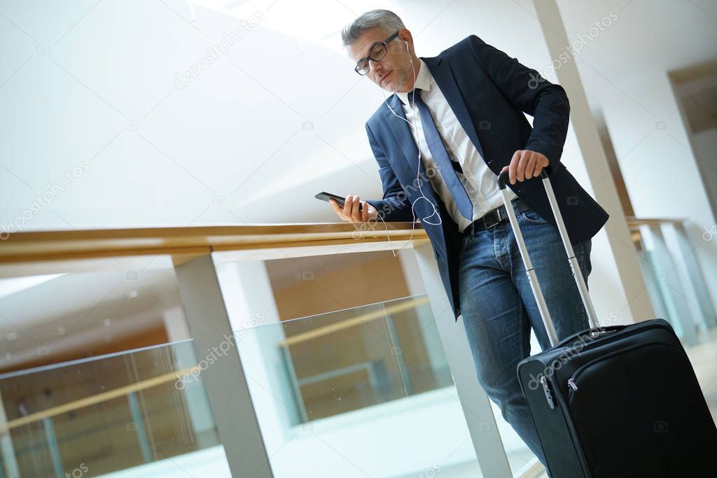 Businessman with suitcase at airport departure hall