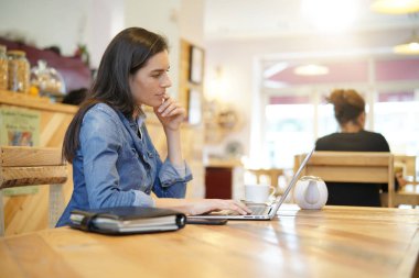 kafede dizüstü bilgisayar üzerinde çalışan kadın