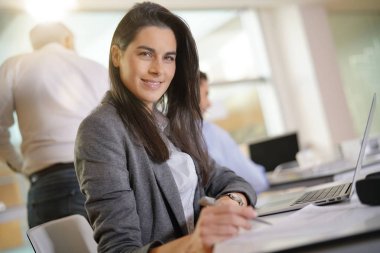 Ofis dizüstü bilgisayar üzerinde çalışan iş kadını