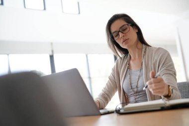 kadın ofiste dizüstü bilgisayar üzerinde çalışan                         