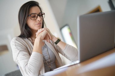 Evden dizüstü bilgisayar üzerinde çalışan kadın