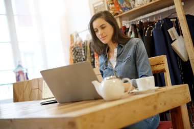 kafede dizüstü bilgisayar üzerinde çalışan kadın