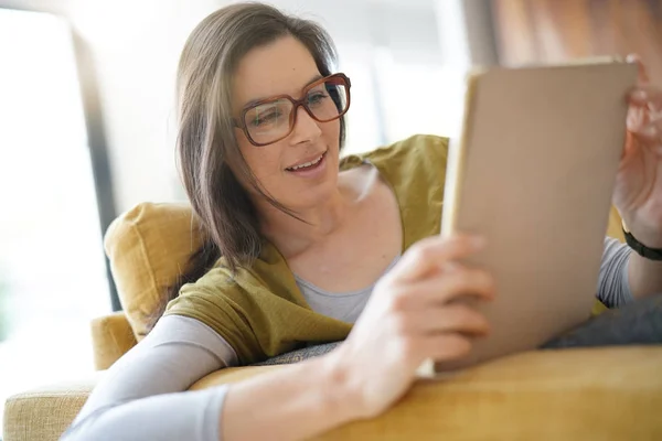 Mulher Morena Com Óculos Usando Tablet Sentado Sofá — Fotografia de Stock