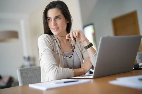Home-office businesswoman looking at  window