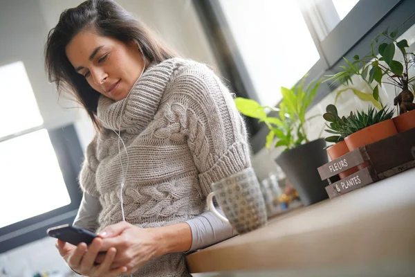 Kulaklık ile telefonda konuşurken uzun saçlı esmer kız