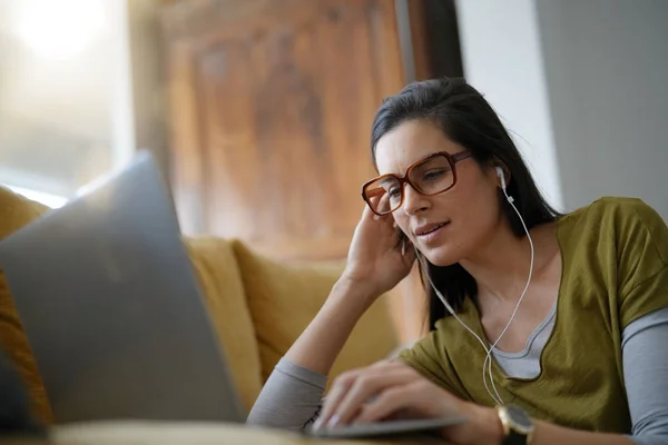 Trendy woman relaxing at home connected with laptop