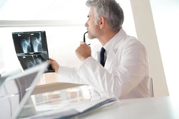 Reifer Arzt Büro Schaut Sich Röntgenergebnisse — Stockfoto