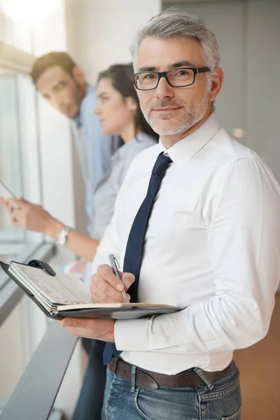 Portrait Homme Affaires Debout Dans Rédaction Bureau Ordre Jour Image En Vente