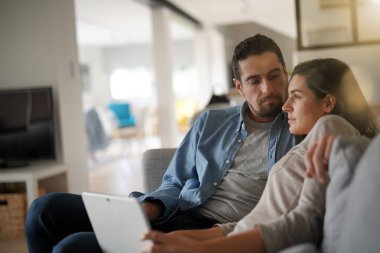 Kanepede rahatlatıcı ve dijital tablet ile bağlı bir çift