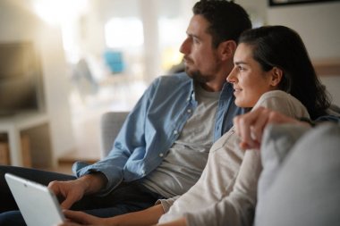 Kanepede rahatlatıcı ve dijital tablet ile bağlı bir çift