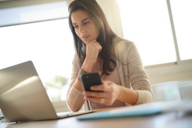 Ofiste çalışan ve smartphone kullanarak başlangıç kız