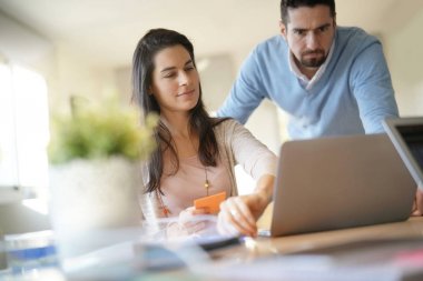 Dizüstü bilgisayarda çalışarak ofiste iş arkadaşları