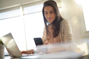 Ofiste çalışan ve smartphone kullanarak başlangıç kız