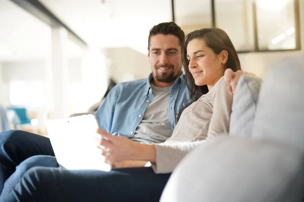 Casal Relaxante Sofá Conectado Com Tablet Digital — Fotografia de Stock