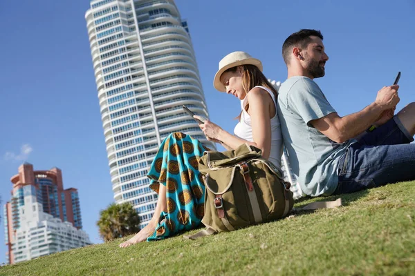 情侣在迈阿密海滨建筑前放松的游客 — 图库照片
