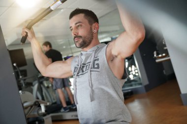 Spor salonunda ağırlık kaldırma atletik adam