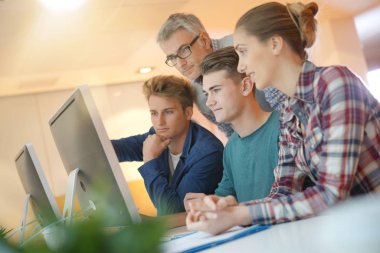 Projede çalışan öğretmenle sınıfta öğrenciler